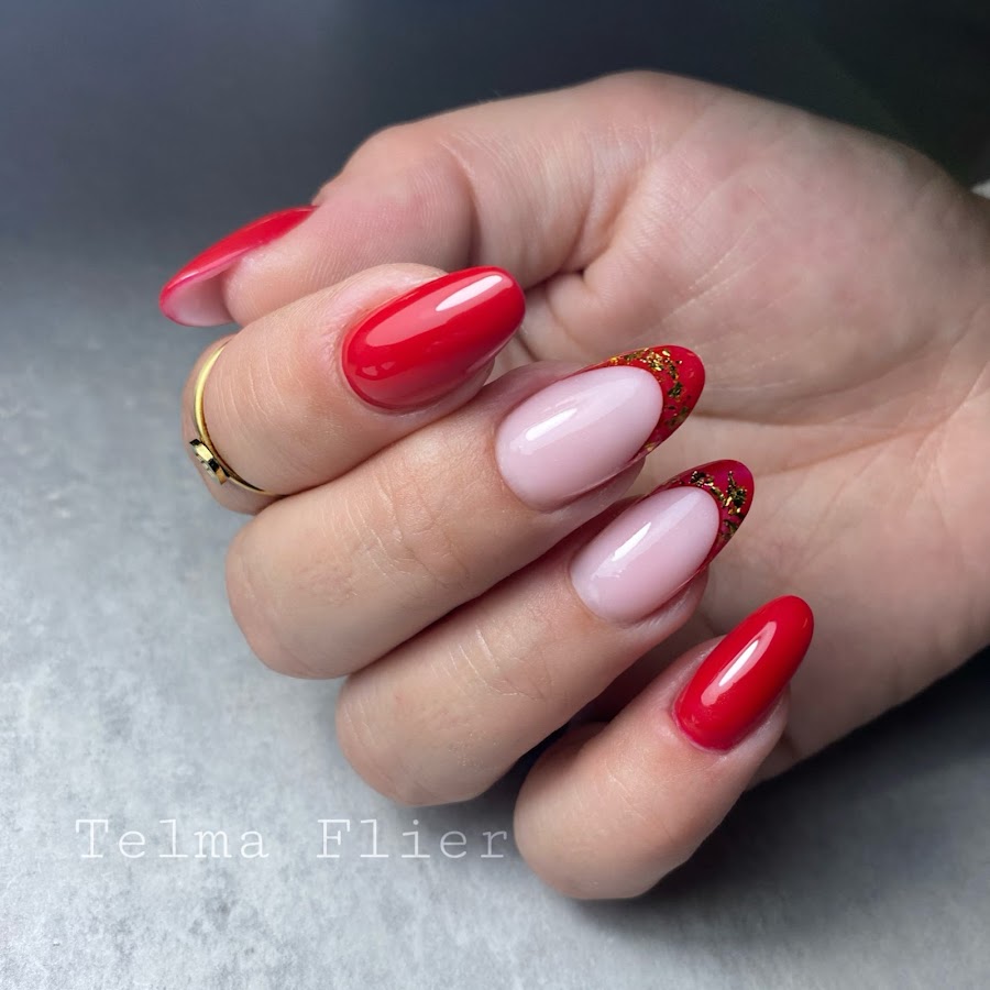 Rode gelnagels met nude french en gouden accenten, gezet door Telma Flier.